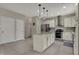 Open kitchen boasts white cabinets, granite countertops, stainless steel appliances, and a functional center island at 11599 Braemar Ct, Carmel, IN 46032