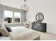 Bright bedroom featuring neutral walls and carpet, a dark dresser with decor, and a large window overlooking nature at 11832 Vale St, Indianapolis, IN 46235