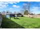 Large fenced backyard with a well-kept lawn, a playset, a fire pit, and an inviting covered patio space at 1280 Casco Bay Cir, Cicero, IN 46034