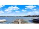Picturesque lake view featuring a wooden dock and boat house under a bright sky with scattered clouds at 1280 Casco Bay Cir, Cicero, IN 46034