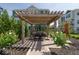 Outdoor pergola with table and chairs is surrounded by landscaping and greenery at 13316 E Lieder Way, Fishers, IN 46037