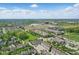 Expansive aerial view of a neighborhood featuring townhomes, green spaces, and a community lake on a sunny day at 13510 E 131St St, Fishers, IN 46037