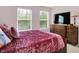 Bedroom with two windows, a wooden dresser, and a velvet-covered bed offering comfort and style at 13510 E 131St St, Fishers, IN 46037