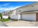 Townhouse exterior with a white fence, a garage, and landscaped yard for curb appeal at 13510 E 131St St, Fishers, IN 46037