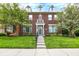 Inviting townhouse featuring a red brick facade, dormer windows, and well-maintained lawn at 13510 E 131St St, Fishers, IN 46037
