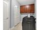 Functional laundry room featuring a washing machine, dryer, white bi-fold doors, and cabinets at 13510 E 131St St, Fishers, IN 46037