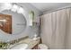 Bathroom with granite countertop vanity, stylish mirror, and shower with patterned curtain at 1417 Macintosh Ct, Avon, IN 46123
