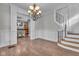 Elegant entryway with hardwood floors, decorative lighting, and staircase leading to a kitchen at 143 W Washington St, Mooresville, IN 46158