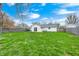 Large backyard with lush grass, a swing set, a fire pit, and a view of the home at 1508 Douglas Dr, Franklin, IN 46131