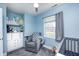 Comfortable Bedroom with blue walls, a gray chair, and a crib with changing table at 1508 Douglas Dr, Franklin, IN 46131