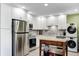 Bright kitchen featuring white cabinetry, stainless steel appliances, and a convenient laundry area at 1508 Douglas Dr, Franklin, IN 46131