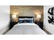 Inviting bedroom featuring a wood accent wall, twin bedside lamps, and coordinating artwork above bed at 15379 Alperton Rd, Fishers, IN 46037