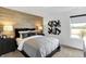 Cozy bedroom with a wood accent wall, plush bedding, and sleek black nightstands for a comfortable stay at 15379 Alperton Rd, Fishers, IN 46037