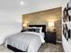 Relaxing bedroom features a wood accent wall, soft lighting, and modern black and white artwork at 15379 Alperton Rd, Fishers, IN 46037