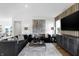 Modern living room with two dark sofas, wood floors, natural lighting, and dark wood entertainment center at 15379 Alperton Rd, Fishers, IN 46037