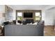 View of a living room with wood floors, neutral walls, an entertainment center, and a gray sofa at 15379 Alperton Rd, Fishers, IN 46037