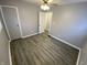 Neutral bedroom with wood-look flooring, ceiling fan with light, closet, and white doors at 1546 Kappes St, Indianapolis, IN 46221