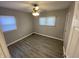 Bright bedroom with wood-look floors, ceiling fan, and ample natural light at 1546 Kappes St, Indianapolis, IN 46221