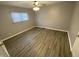 Neutral bedroom with wood-look flooring, ceiling fan with light, and natural light at 1546 Kappes St, Indianapolis, IN 46221