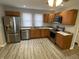 Modern kitchen featuring stainless steel appliances, wood cabinetry, granite countertops, and sleek vinyl flooring at 1546 Kappes St, Indianapolis, IN 46221