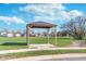 New gazebo in a large green lawn with mature trees surrounding it and blue skies above at 1616 Capra Ct, Beech Grove, IN 46107