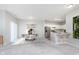 Open-concept living and dining area adjacent to kitchen with white cabinets and stainless appliances at 1616 Capra Ct, Beech Grove, IN 46107