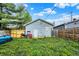 An outdoor view showing the house's backyard, a lawn, a wooden fence and a barbecue grill at 1719 Dawson St, Indianapolis, IN 46203