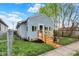 Light-blue home with a wood porch, a sidewalk, a side fence, and newly planted shrubbery at 1719 Dawson St, Indianapolis, IN 46203