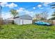 Backyard featuring a detached garage with a white door, and a parked blue car on the side at 1719 Dawson St, Indianapolis, IN 46203