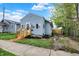 Exterior angle of a light-blue home featuring a newly renovated porch, side yard, and a gravel driveway at 1719 Dawson St, Indianapolis, IN 46203