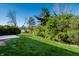 Backyard featuring a well-maintained lawn, mature trees, and a concrete patio at 1720 Justin Ct, Indianapolis, IN 46219
