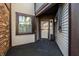 Inviting front porch with stylish black carpeting, brick accents, and a charming entry door at 1720 Justin Ct, Indianapolis, IN 46219