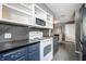 Well-lit kitchen with stainless steel appliances, dark countertops, and gray tile flooring at 1720 Justin Ct, Indianapolis, IN 46219