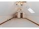 Finished attic with neutral carpet, wood trim, two ceiling fans, a window, and an attached bathroom at 1853 Water Oak Ct, Avon, IN 46123