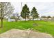 Green backyard featuring a small patio, shed, trees, and a potential fire pit at 1965 Churchill Rd, Franklin, IN 46131