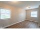 Bright bedroom featuring modern wood flooring, neutral walls, and natural light from two windows at 2109 N Janney Ave, Muncie, IN 47304