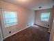 Simple bedroom with neutral walls, carpeted floor, and natural light from two windows at 2109 N Janney Ave, Muncie, IN 47304