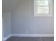 Bedroom featuring wood paneling, carpeted floors, and a bright window showcasing natural light at 2109 N Janney Ave, Muncie, IN 47304