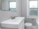 A close up shot of a well lit bathroom featuring a white vanity and white toilet at 217 W 35Th St, Indianapolis, IN 46208
