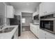 Renovated kitchen with stainless steel appliances and gray flooring, and view to another room at 217 W 35Th St, Indianapolis, IN 46208