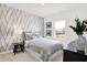 Serene bedroom with a textured accent wall, soft lighting, and tasteful decorations creating a peaceful retreat at 2212 Foothill Dr, Greenfield, IN 46140