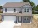 Charming two-story home showcasing a covered porch, attached two-car garage, and gray siding at 24517 Wallace St, Sheridan, IN 46069