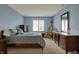 Spacious bedroom featuring blue walls, large window, rocking chair, and wooden dresser at 2979 Amherst St, Indianapolis, IN 46268