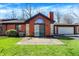 Back exterior view of brick home showcasing patio area with outdoor seating and attached garage at 2979 Amherst St, Indianapolis, IN 46268