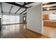 Open-concept living area featuring hardwood floors, beamed ceilings, and a view of the kitchen at 318 Camby St, Greenwood, IN 46142