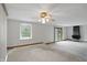 Bright living room featuring a ceiling fan, fireplace, sliding door, and neutral carpet at 318 Camby St, Greenwood, IN 46142