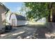 View of backyard with a shed, concrete pad, a large tree and partial fence at 3241 N Capitol Ave, Indianapolis, IN 46208