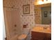 Cozy bathroom featuring a tub-shower combo, vanity with sink, toilet and patterned wallpaper at 3504 Inverness Blvd, Carmel, IN 46032