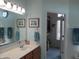 Bright bathroom with double vanity, wood cabinets, a large mirror, and an adjoining walk-in closet at 3504 Inverness Blvd, Carmel, IN 46032