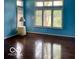 Inviting living room featuring bright blue walls, large windows with shutters, and hardwood floors at 3504 Inverness Blvd, Carmel, IN 46032